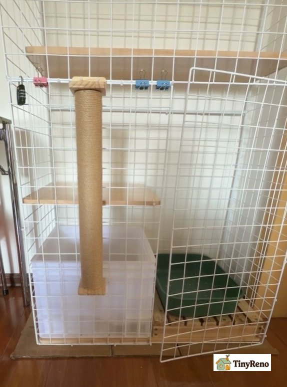 Tall sisal rope cat scratcher standing beside wooden door frame with clear packing tape